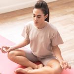 brunette-fitness-woman-sit-on-rug-indoors-at-home-QAQEEZX.jpg